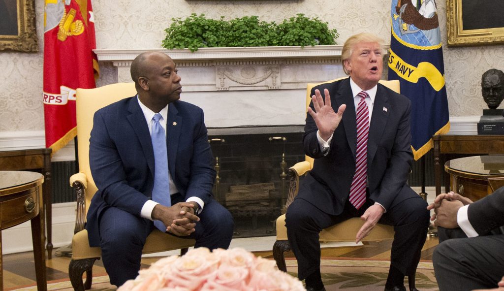 President Donald Trump, with Sen. Tim Scott, R-S.C., second from left, and Ivanka Trump, top right, participate in a working session regarding the opportunity zones provided by tax reform in the Oval Office of the White House, Wednesday, Feb. 14, 2018, in Washington.