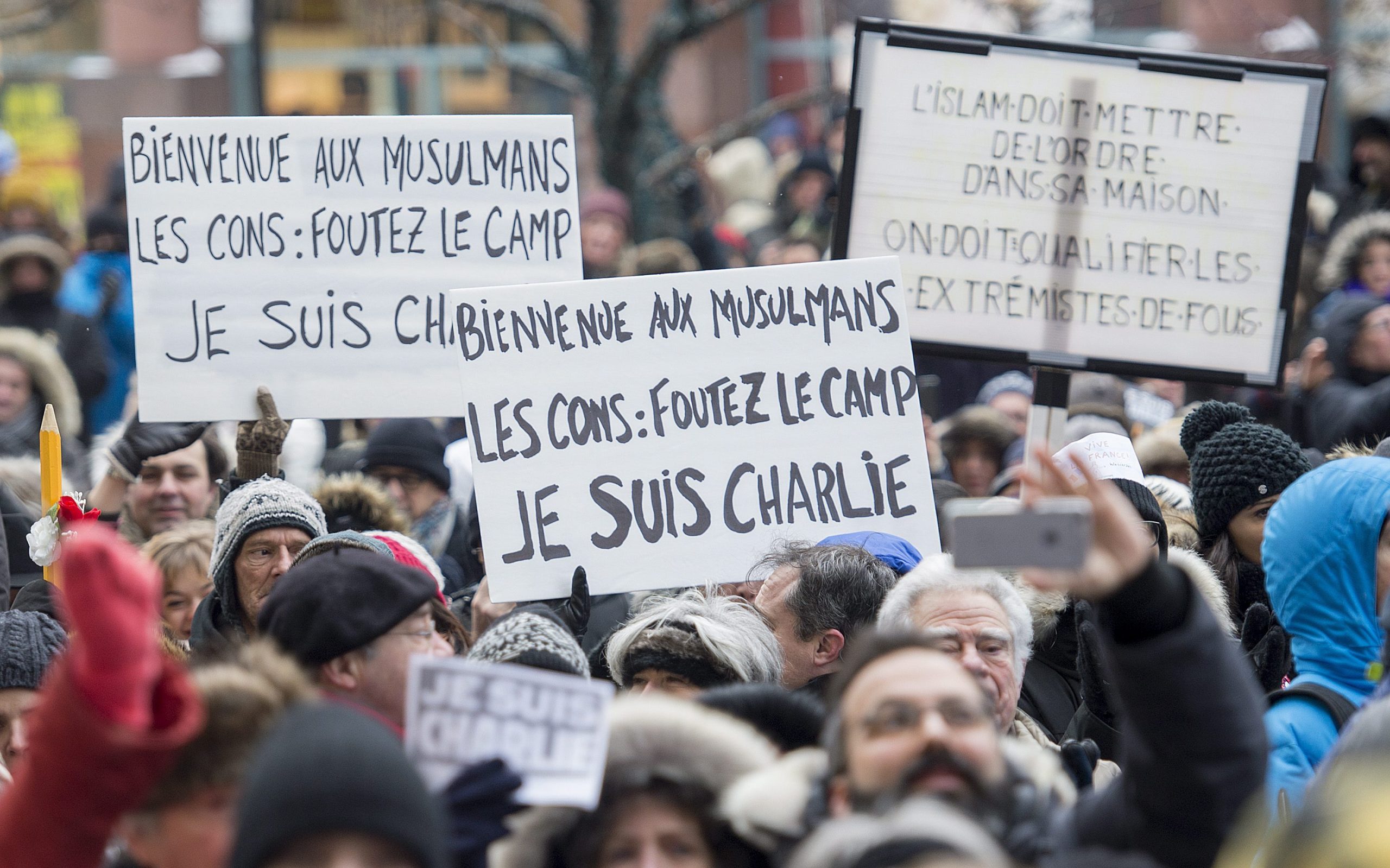 People hold up signs during a solidarity rally in support of all the victims who lost their lives during recent terrorist attacks in France, Sunday, Jan. 11, 2015, in Montreal. (AP Photo/The Canadian Press, Graham Hughes)