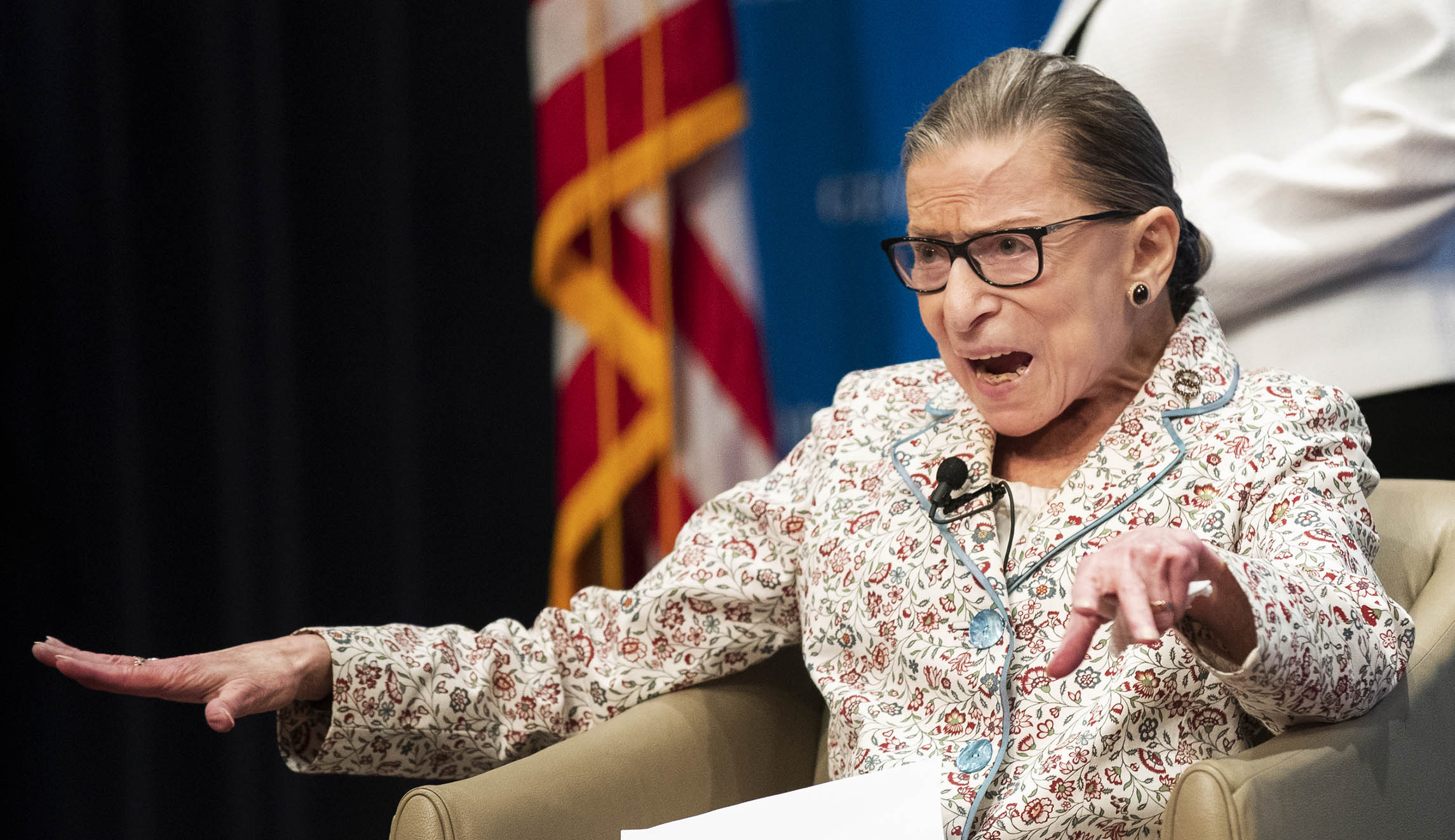Supreme Court Associate Justice Ruth Bader Ginsburg gestures as the invited guests applaud while she gets seated at Georgetown University Law Center in Washington.