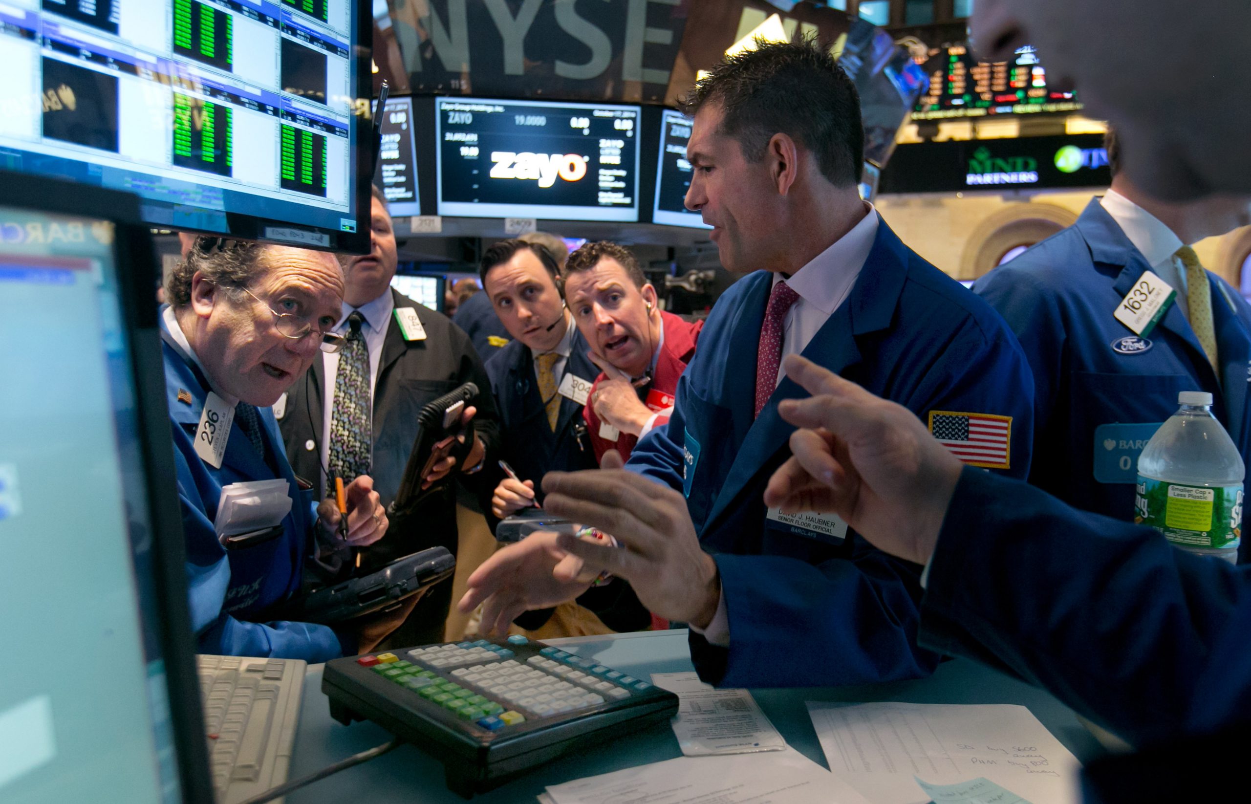Specialist David Haubner works with traders at his post on the floor of the New York Stock Exchange, Friday, Oct. 17, 2014. U.S. stocks opened higher Friday as investors weighed the latest corporate earnings news and data showing home construction picked up last month. (AP Photo/Richard Drew)