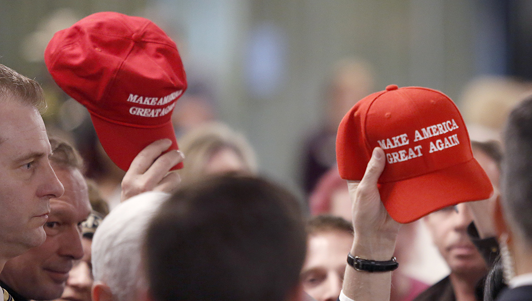 Members in the audience hold up "Make America Great Again" hats at the conclusion of a speech by Vice President Mike Pence at the America First Policies, "Tax Cuts to Put America First" event Thursday, March 22, 2018, in Manchester, N.H. 