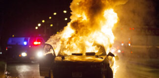 A car burns as a crowd gathers following the fatal shooting of a man in Milwaukee, Saturday, Aug. 13, 2016. (Calvin Mattheis/Milwaukee Journal-Sentinel via AP)