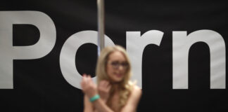 Pornography actress Ginger Banks stands in the Pornhub booth during the AVN Adult Entertainment Expo on Wednesday, Jan. 24, 2018, in Las Vegas.