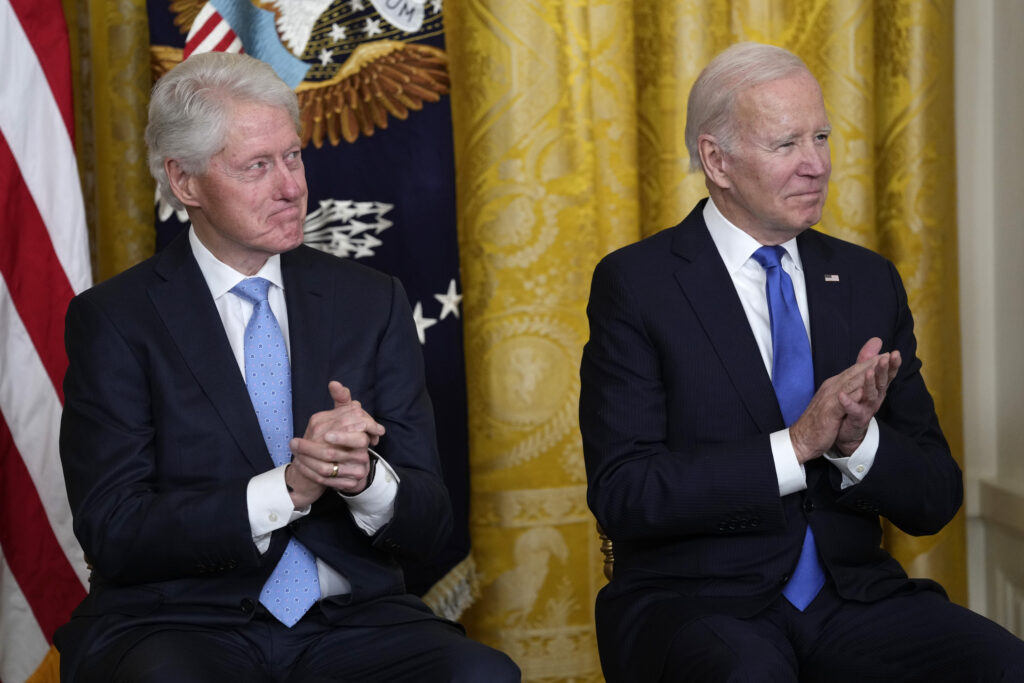 President Joe Biden and former President Bill Clinton listen as Vice President Kamala Harris speaks during an event in the East Room of the White House in Washington, Thursday, Feb. 2, 2023, to mark the 30th Anniversary of the Family and Medical Leave Act.