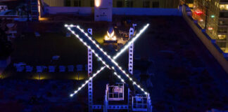 Workers install lighting on an "X" sign atop the company headquarters, formerly Twitter, in San Francisco on July 28, 2023. One year ago, Elon Musk began transforming the social media platform into what is now known as X.