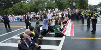   FILE - This Aug. 1, 2013 file photo shows immigration reform supporters blocking a street on Capitol Hill in Washington. For many House conservatives, President Barack Obamaâs decision to delay a central provision of his health care law has emerged as a major stumbling block _ not to health coverage, but to an immigration bill. (AP Photo/Manuel Balce Ceneta, File)  