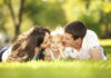How marriage motivates men to be better Happy mother and father kissing their daughter in the park