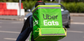 An Uber Eats food delivery courier delivers food.