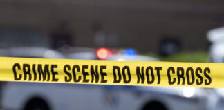 FILE - Yellow crime tape blocks off an area near a mall parking area where two Baltimore city police officers were shot and a suspect was killed as a U.S. Marshals' task force served a warrant, July 13, 2021, in Baltimore, Md. (AP Photo/Jose Luis Magana, File)