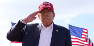 FILE - Republican presidential candidate former President Donald Trump salutes at a campaign rally March 16, 2024, in Vandalia, Ohio. Trump is making the Jan. 6, 2021 attack on the Capitol a cornerstone of his bid to return to the White House. Trump opened his first rally as the presumed Republican Party presidential nominee standing in salute with a recorded chorus of Jan. 6 prisoners singing the national anthem.(AP Photo/Jeff Dean)